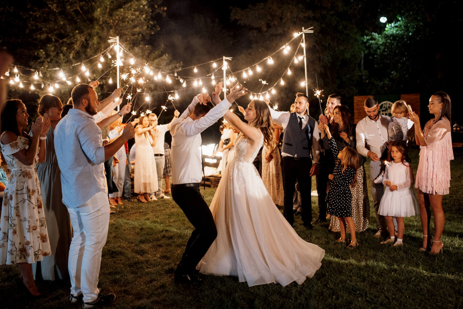 bride and groom are dancing, and the weddings guests are standing around them