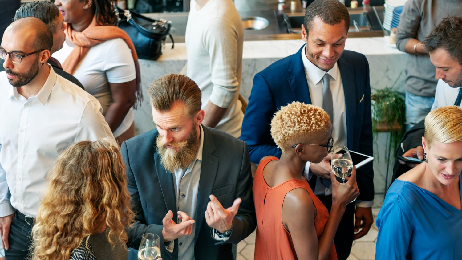 many diverse people at a wedding party, talking and drinking