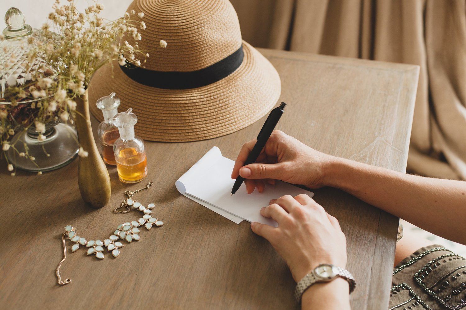 woman sitting on a desk writing down notes on a piece of paper