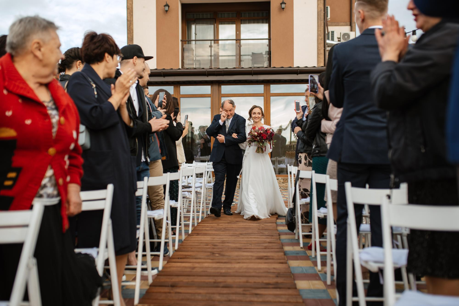 the bride is walking down the aisle with her crying father