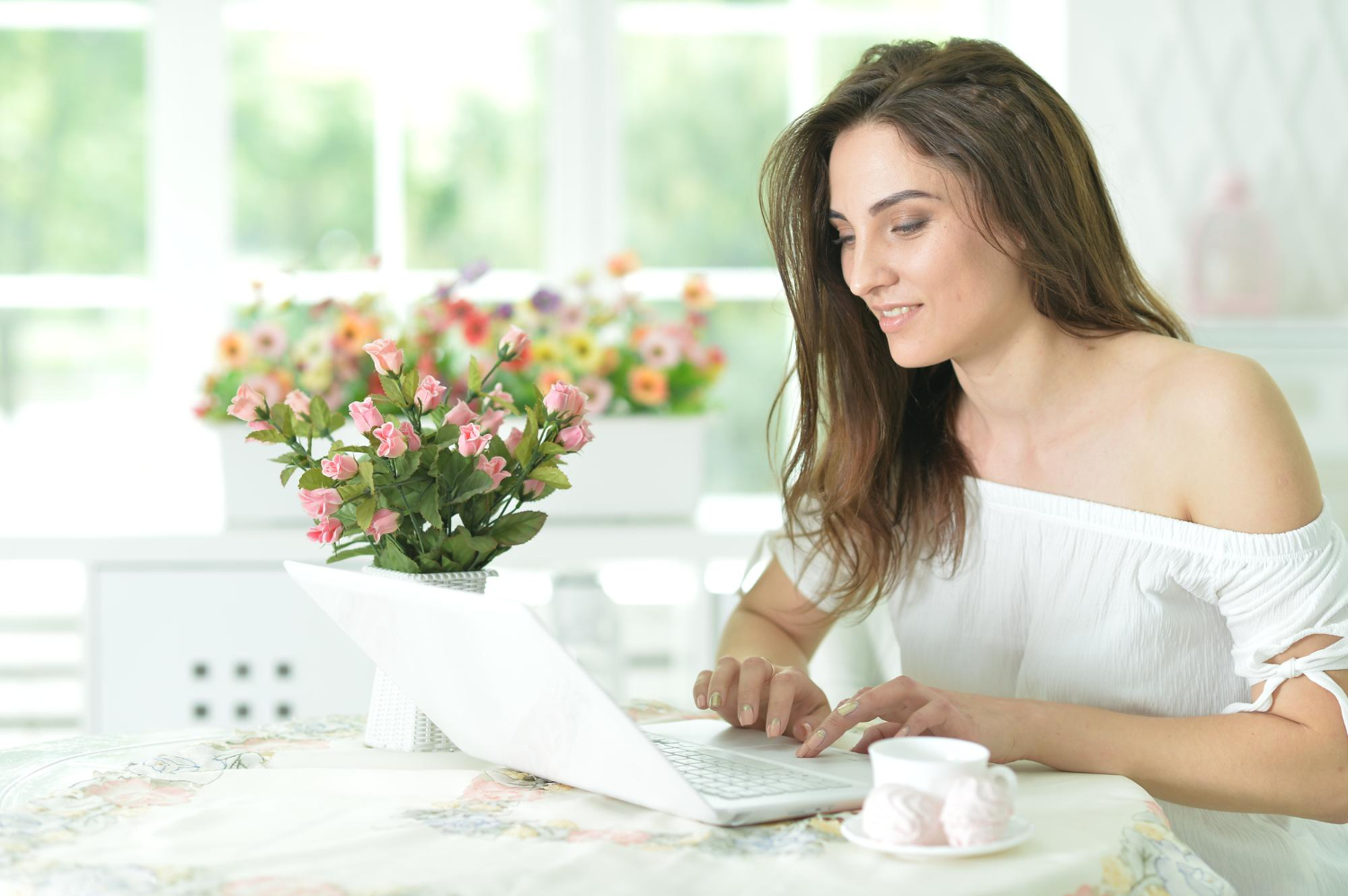 woman sitting on a table using a laptop