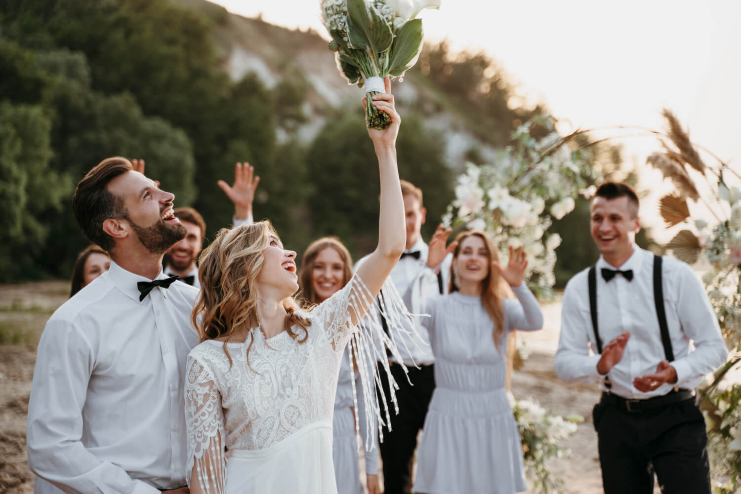 a bride is throwing a flower bouquet behind her, where the guests are standing