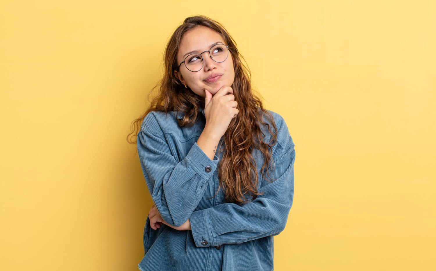 brown haired woman with glasses thinking about something