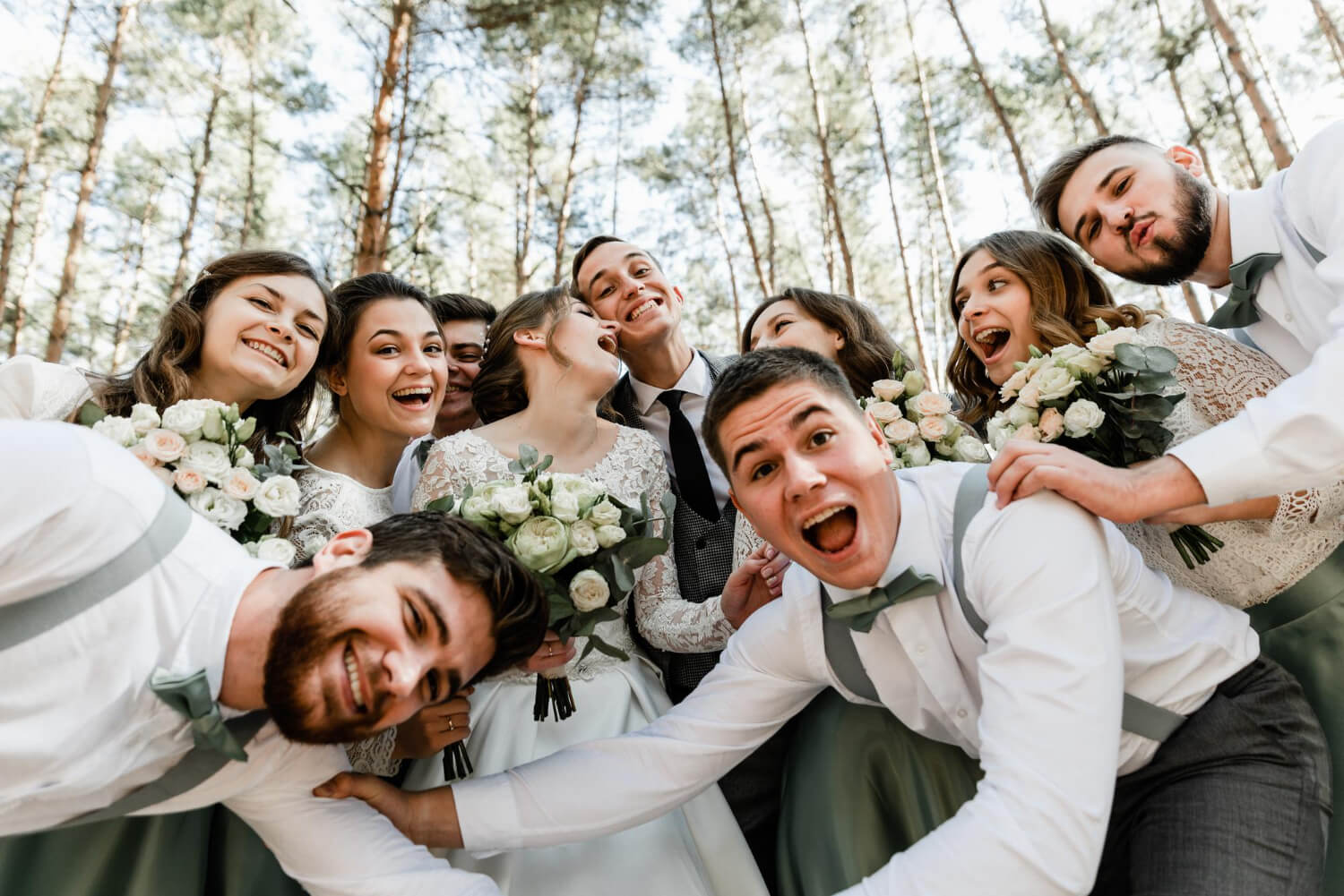 the bride and the groom and a group of their friends are having fun taking a selfie