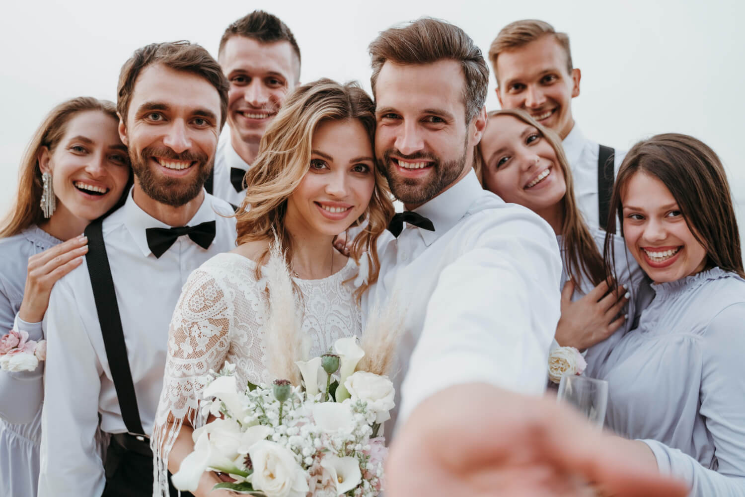 bride and groom together with their close friends take selfie on wedding day