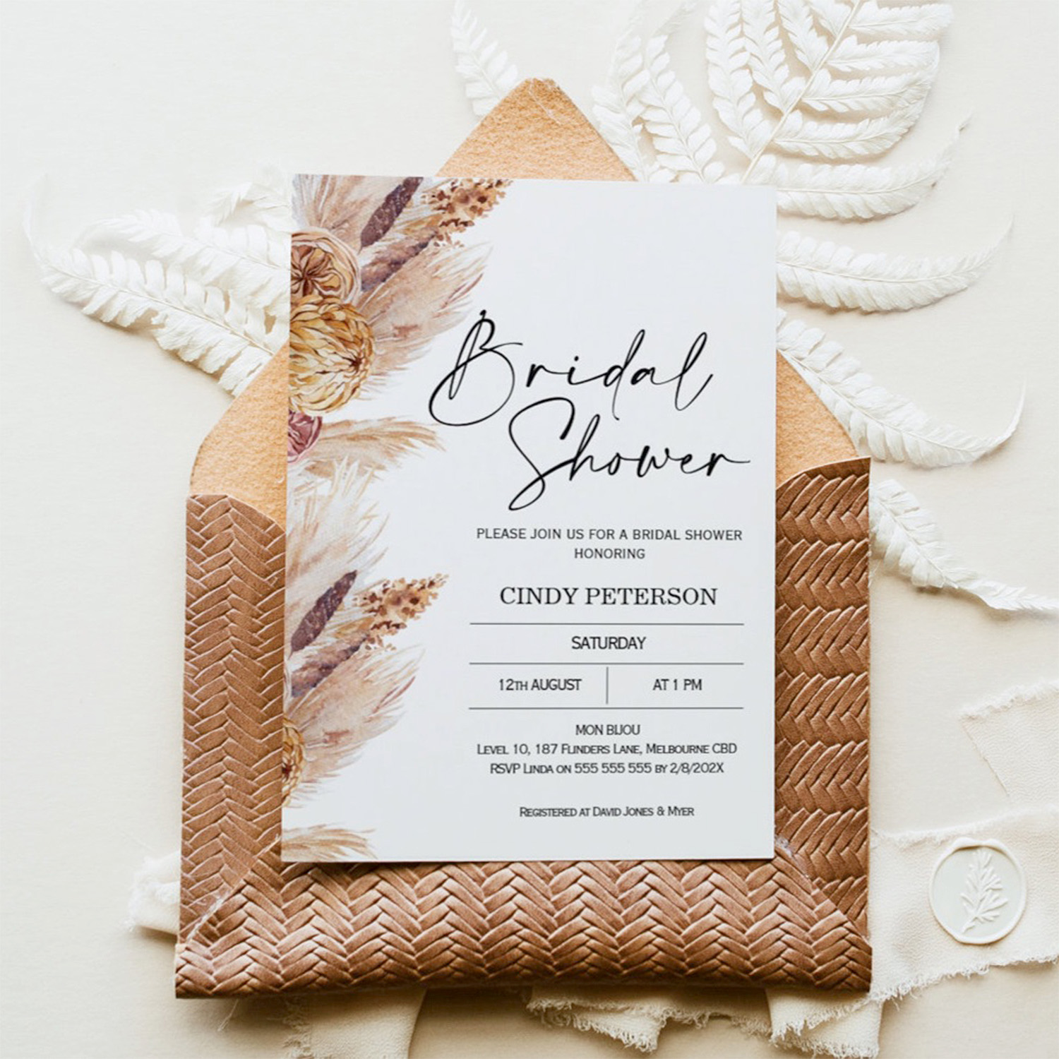 boho themed invitation card with a brown envelope