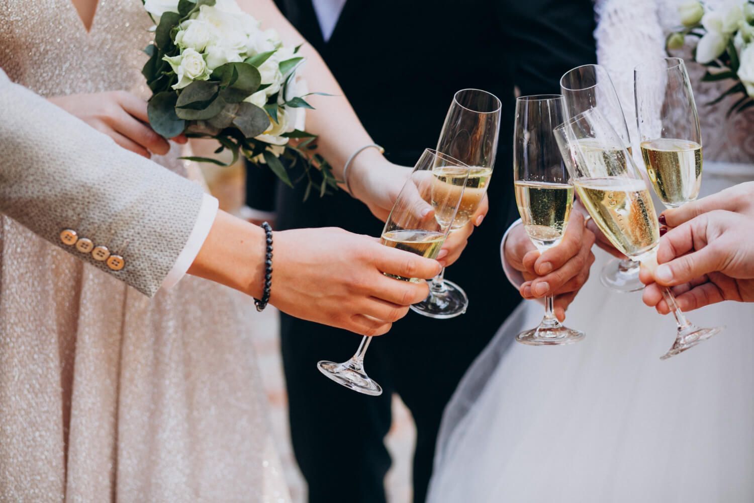 five people, including the bride and the groom, holding their champagne glasses together