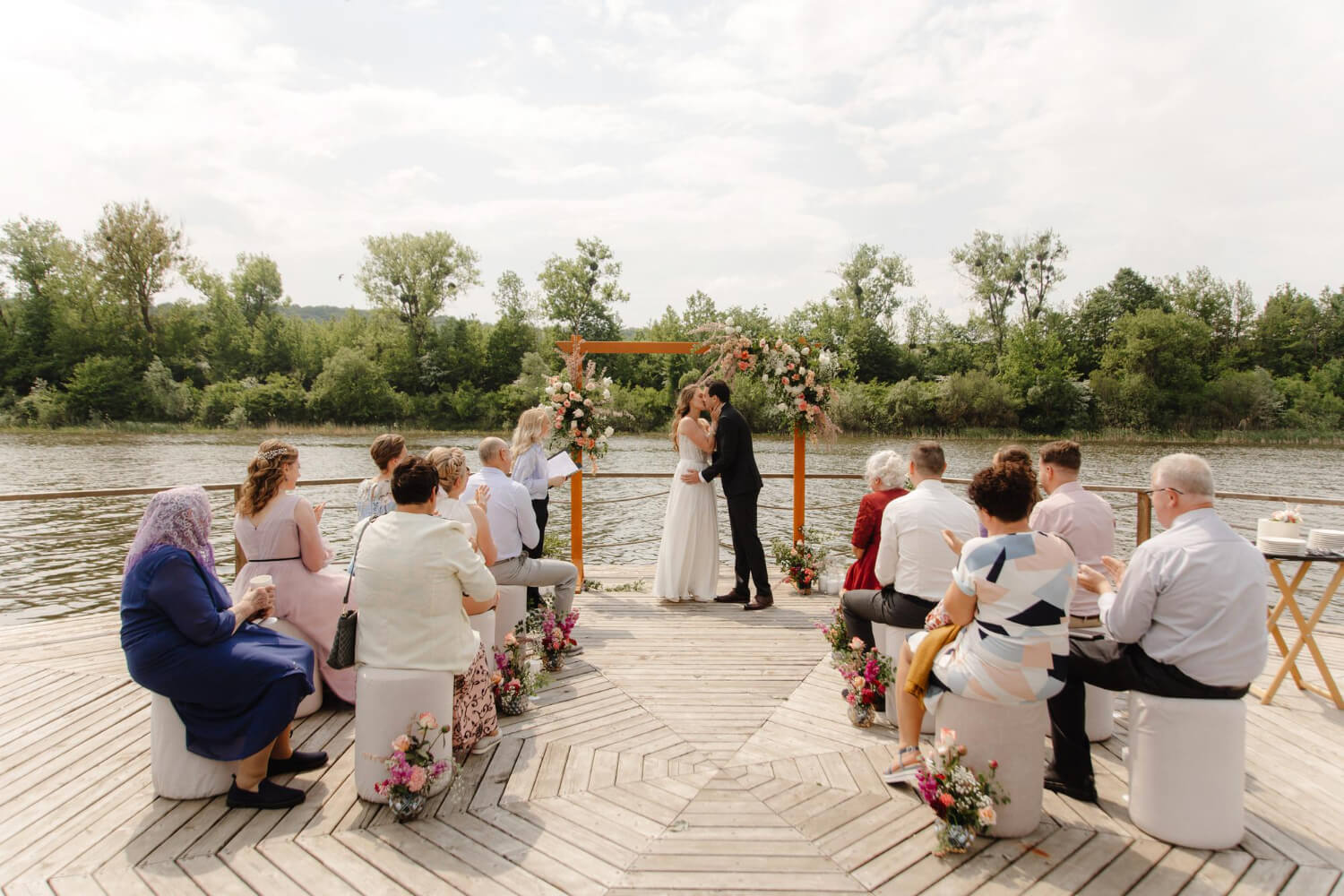 a small wedding ceremony next to a lake