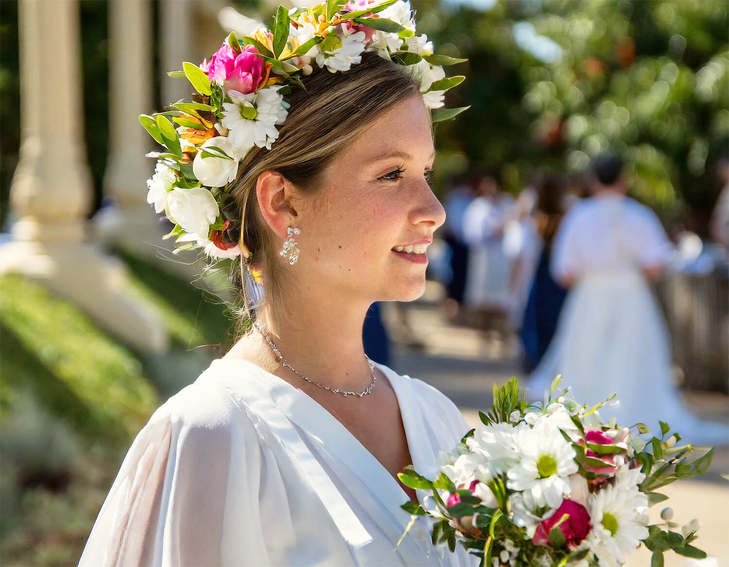 a bride with a flower crown in her hair holding a flower bouquet