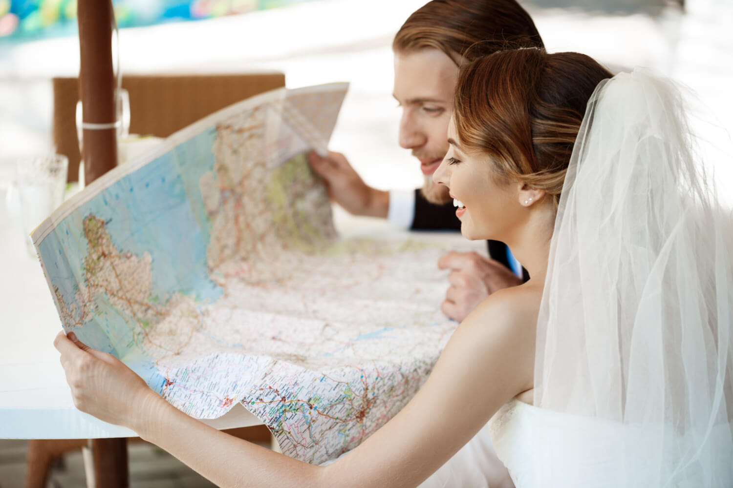 the bride and the groom looking at a large paper map