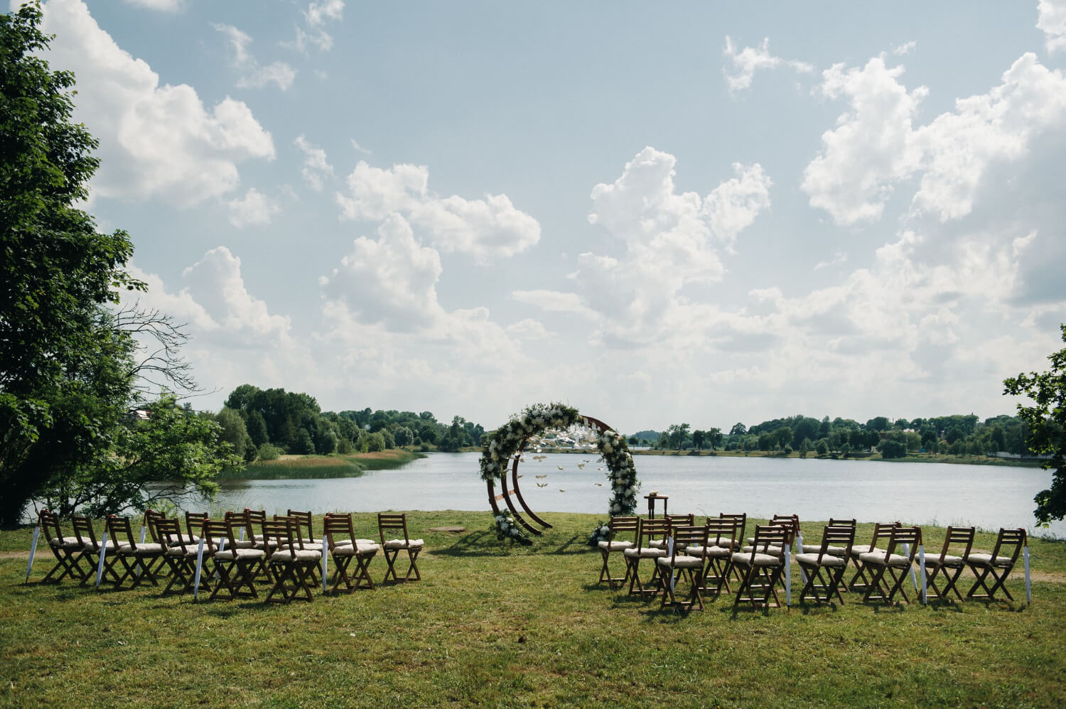 a wedding venue prepared for the ceremony in front of a lake