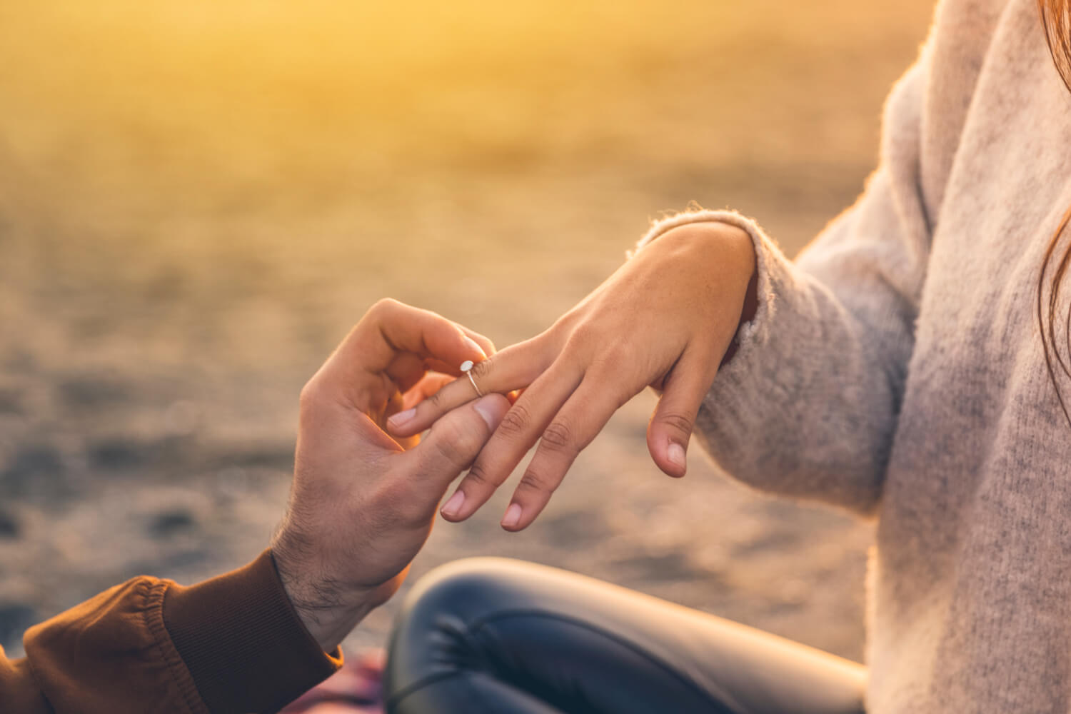 a man putting a ring on a woman's finger