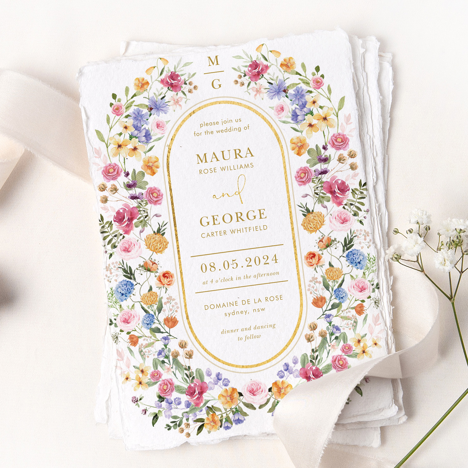 a stack of printed wedding invitations with a wildflower theme