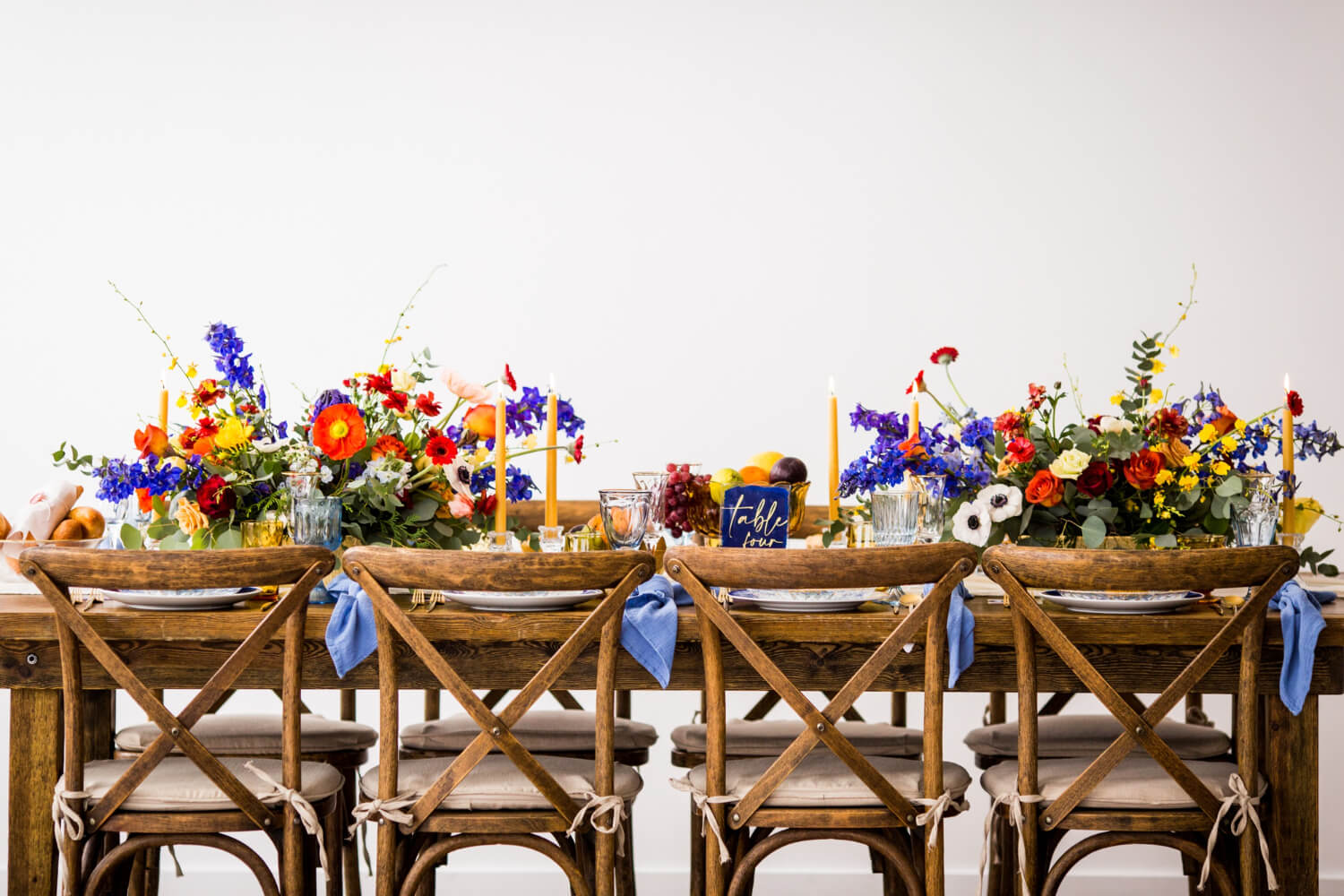 a wedding dining table decorated with colorful wild flowers